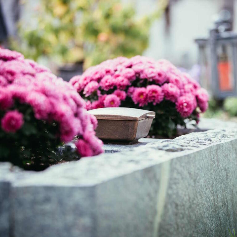 Grabstein mit Blumen. Verlassen Sie sich im Trauerfall auf unseren Bestatter in Velbert.