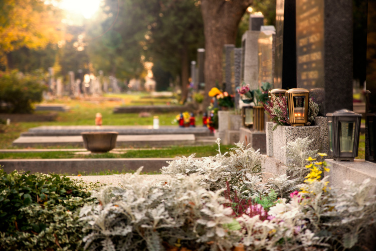 Gepflegte Grabstätten auf einem Friedhof mit Blumen und Laternen als Sinnbild für stille Erinnerung und Begleitung durch einen Bestatter in Dinslaken.